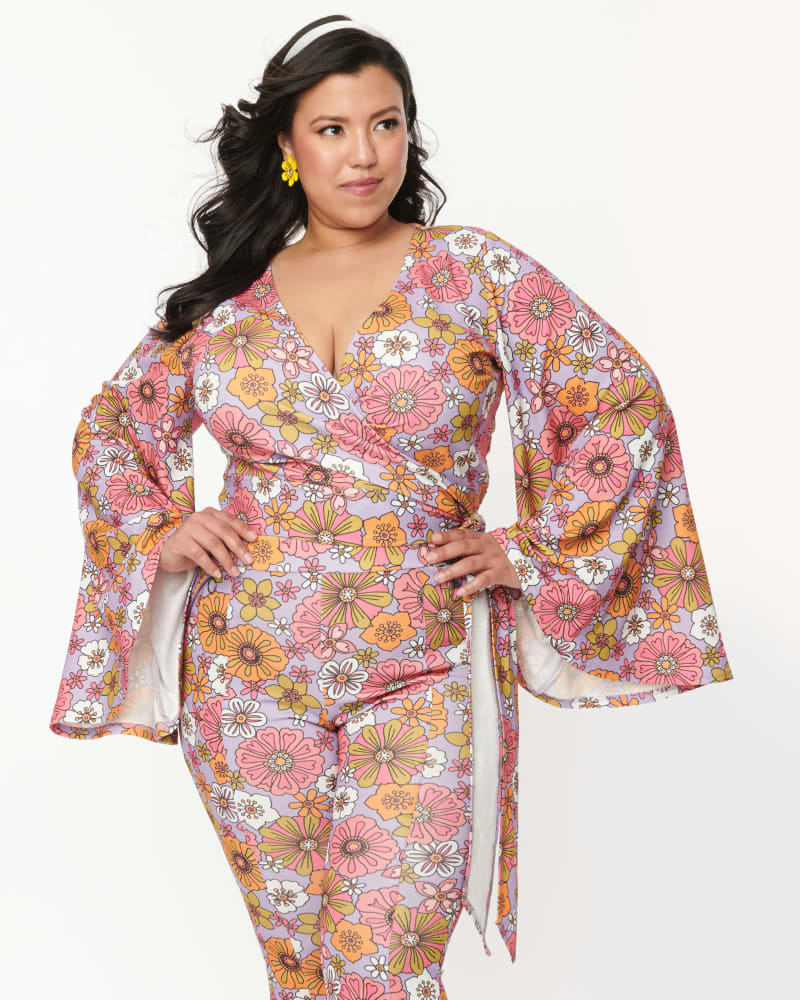 Front of a model wearing a size 1X Smak Parlour Lavender Retro Bloom Bell Sleeve Wrap Top in Lavender Retro Bloom by Smak Parlour. | dia_product_style_image_id:340692